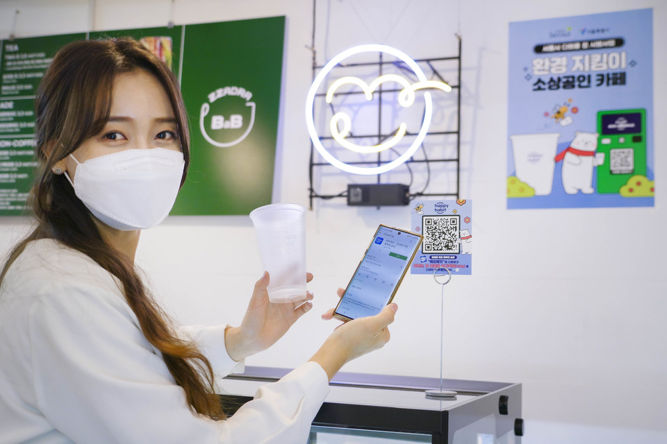 SK텔레콤 모델이 다회용컵 반납기 앞에서 포즈를 취한 모습. (사진=SK텔레콤 제공)