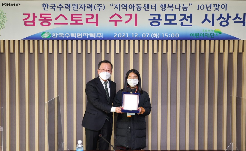 초록우산어린이재단은 지난 7일 한국수력원자력㈜ 본사에서 ‘지역아동센터 행복나눔’사업 10년맞이 수기 공모전 시상식을 개최하고 기념사진을 촬영하고 있다. (왼쪽부터 한국수력원자력㈜ 이인식 기획본부장, 마루지역아동센터 김인주 아동). (사진=초록우산어린이재단 제공)