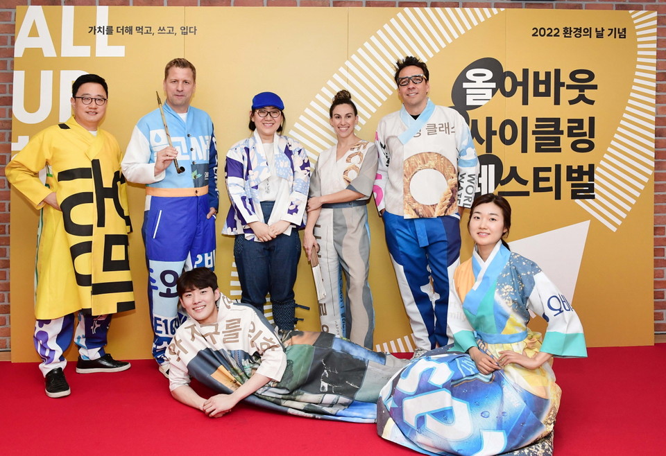 [사진1. 세계 환경의 날을 앞두고 2일 오비맥주 본사에서 열린 ‘업사이클링 페스티벌’에서 (뒷줄 왼쪽부터) 임직원 모델 정책홍보부문 구자범 수석부사장, 배하준 대표이사, 다시곰 이승주 디자이너, 구매부문 나탈리 부사장, 마케팅부문 알렉스 부사장이 현수막으로 제작한 모던한복을 입고 기념사진을 찍고 있다. (사진=오비맥주 제공)