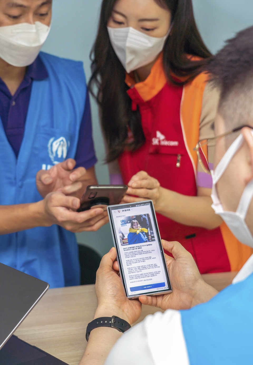 SKT와 유엔난민기구 직원들이 SKT RCS비즈웹을 통해 발송한 메시지를 소개하는 모습. (사진=SKT 제공)