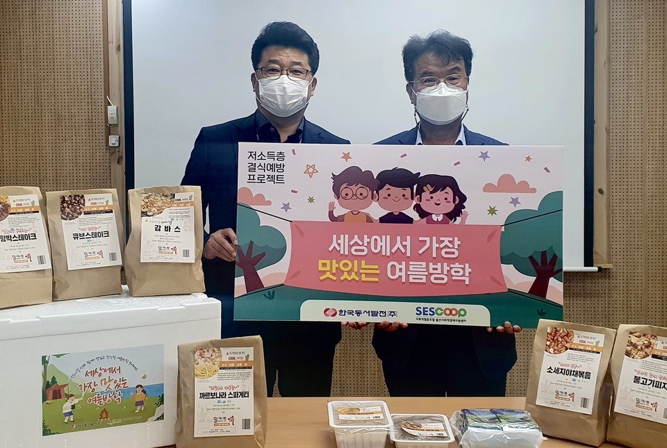 '세상에서 가장 맛있는 여름방학' 캠페인에서 결식 우려 아동에게 전달할 특식꾸러미들 앞에서 (왼쪽부터)신용민 한국동서발전 인재경영처 사회공헌부장과 문흥석 울산사회적경제지원센터장이 기념사진을 촬영하고 있다. (사진=동서발전 제공)