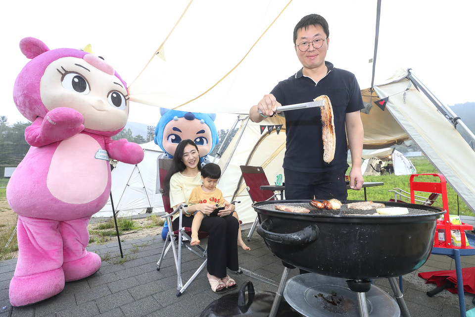 KT 고객이 키즈랜드 꼬마요정 유니, 파비와 함께 캠핑장에서 바베큐를 즐기는 모습. (사진=KT 제공)