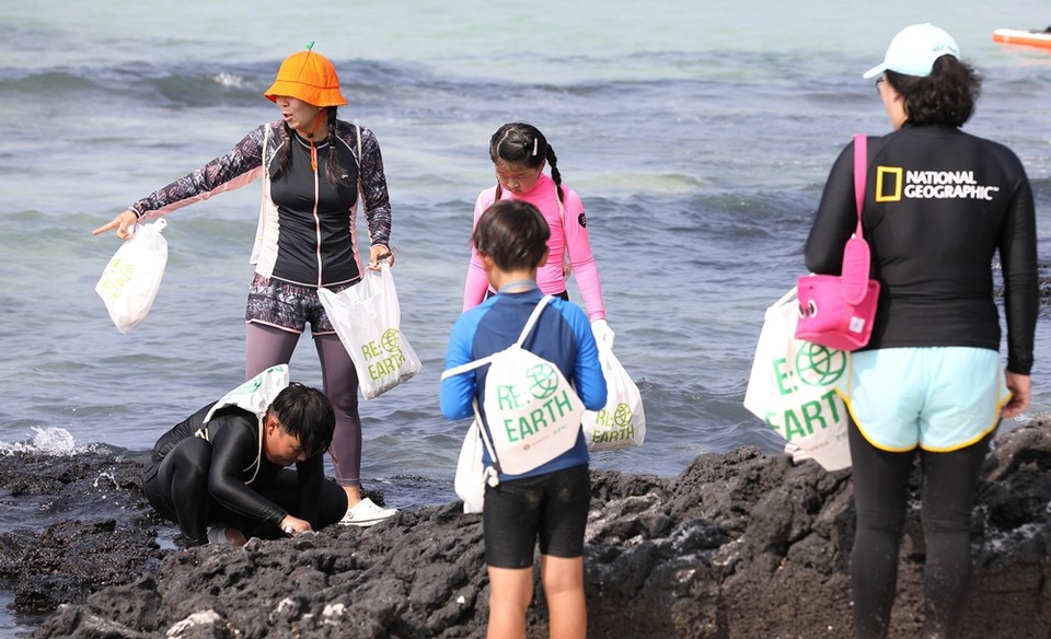제주 월정리 해수욕장에서 고객들이 리얼스 비치코밍 캠페인에 참여하고 있는 모습. (사진=롯데쇼핑 제공)