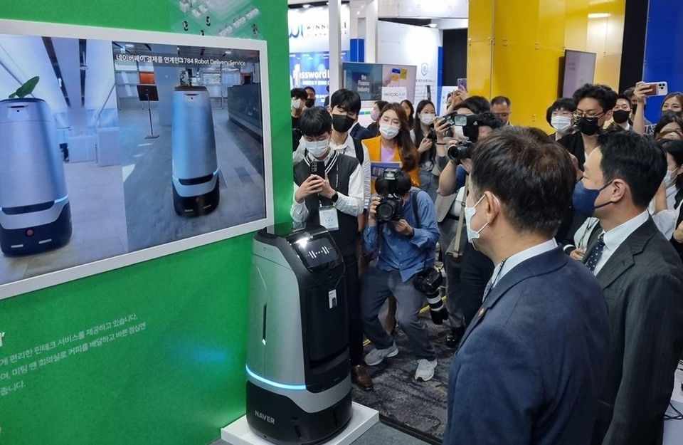 김주현 금융위원장(왼쪽)이 박상진 네이버파이낸셜 대표(오른쪽)와 함께 28일 오전 ‘코리아 핀테크 위크 2022’ 현장에서 네이버페이 결제와 연결된 자율주행 배달로봇 ‘루키’에 대한 소개 영상을 보고 있다. (사진=네이버파이낸셜 제공)