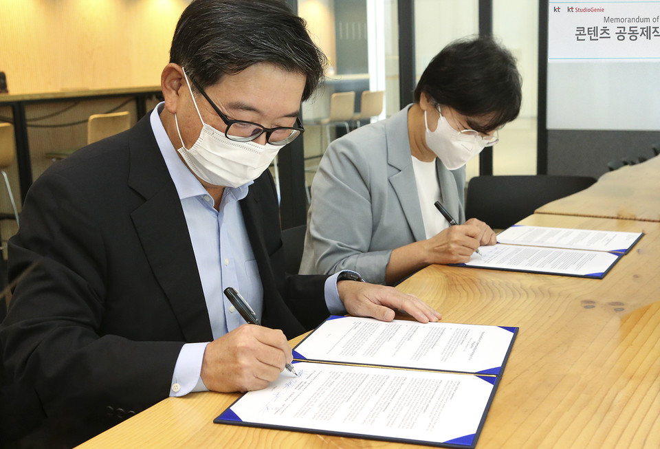 (왼쪽부터)KT 미디어플랫폼사업본부장 김훈배 전무와 KT스튜디오지니 김철연 대표가 업무협약 체결 사인을 하는 모습. (사진=KT 제공)