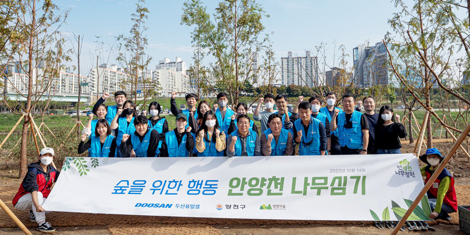 14일, 두산퓨얼셀 임직원들이 안양천에서 360그루의 나무를 심은 뒤, 기념사진을 촬영하고 있다. (사진=두산퓨얼셀 제공)