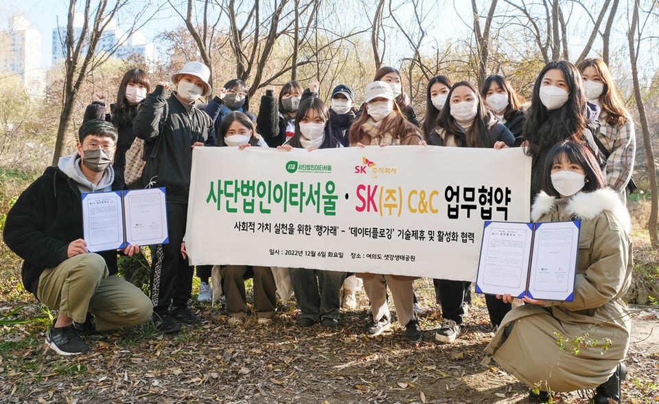 6일 서울 여의도 샛강생태공원에서 열린 ‘ESG가치 창출 확산 위한 행가래-데이터플로깅 제휴 협약식’ 후 SK㈜ C&C 강지현 매니저(왼쪽 하단), 이타서울 한유사랑 대표이사(오른쪽 하단)와 플로깅 참여 청년들이 기념 사진을 찍는 모습. (사진=SK㈜ C&C 제공)