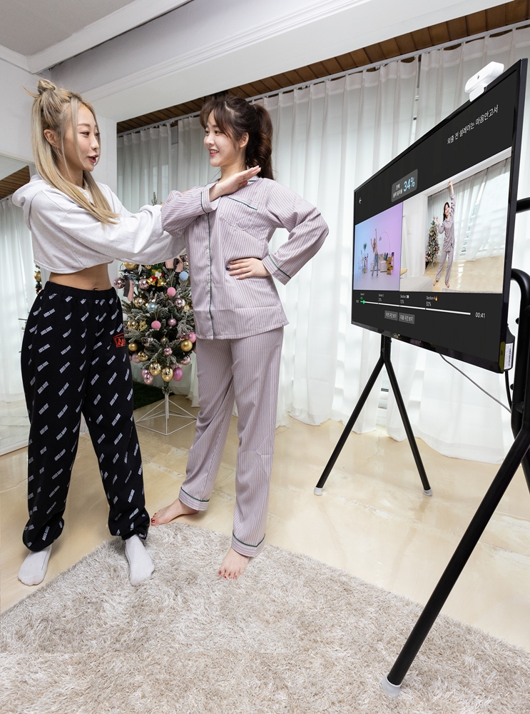 원밀리언댄스 소속 안무가 에이미 팍(amy park)이 지니 TV의 원밀리언 홈댄스(1M HomeDance) AI 코칭 튜토리얼 서비스 체험을 돕고 있는 모습. (사진=KT 제공)