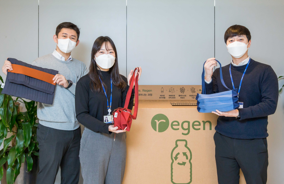 효성티앤씨 직원들이 사내 페트병 수거함 앞에서 친환경 섬유 리젠으로 만든 가방을 선보이고 있다. (사진=효성 제공)