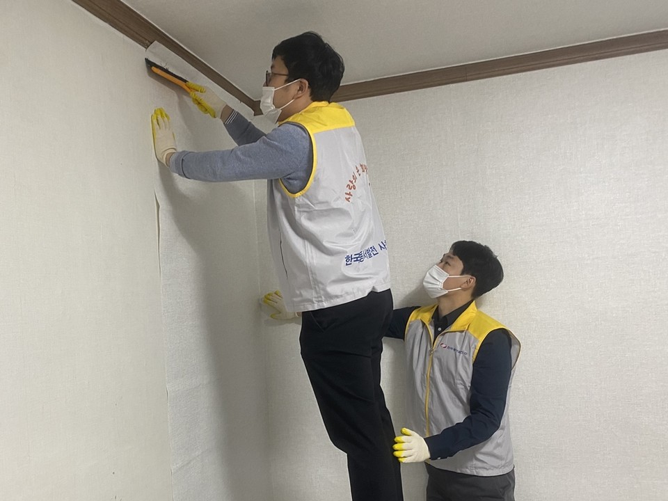  '신박한 에너지 정리' 수혜가구인 울산시 동구 긴급위기보호아동 위탁 저소득층 가정에서 동서발전 직원들이 도배작업 일손을 돕고 있는 모습. (사진=한국동서발전 제공)