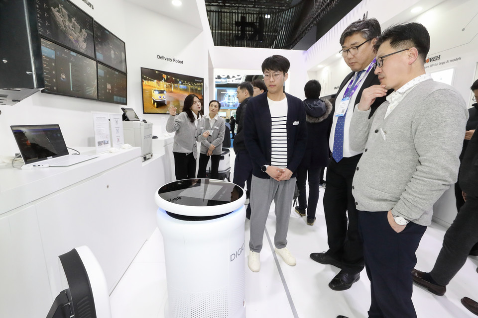 27일(현지시간) KT 전시관 내에서 직원이 관람객에게 방역로봇 기능을 시연하고 있다. (사진=KT 제공)
