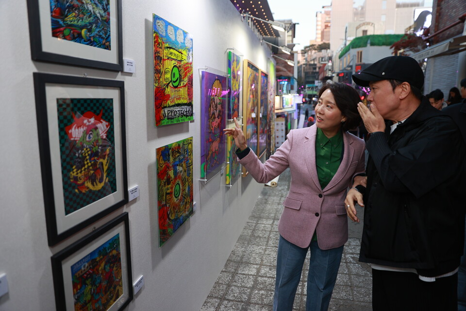 이영 중소벤처기업부 장관(왼쪽)이 이태원 재도약을 위해 8일 서울 이태원 세계음식거리를 방문해 가수 정원관(오른쪽)과 함께 '헤이, 이태원' 4월 거리전시회를 관람하고 있다. (사진=제공)