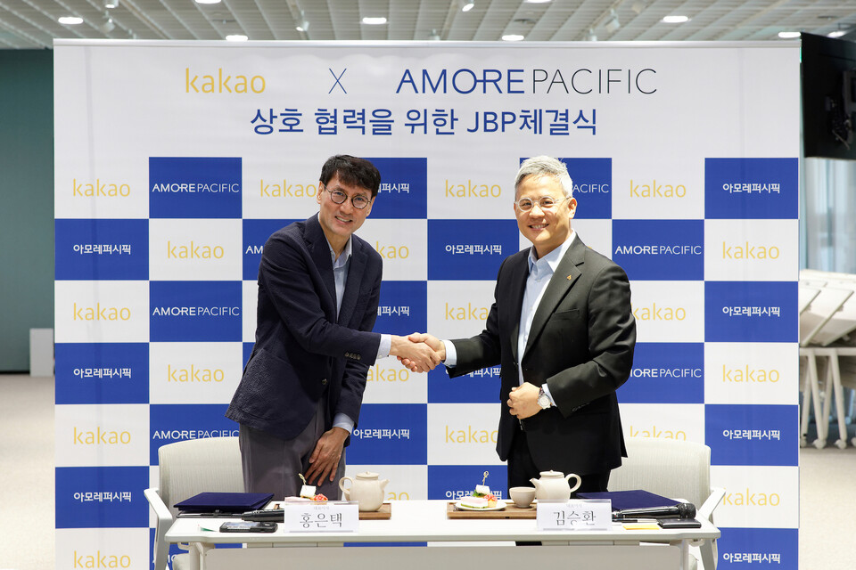 8일 오전 서울 용산구 아모레퍼시픽 본사에서 열린 업무협약식에서 홍은택 카카오 대표이사(왼쪽)와 김승환 아모레퍼시픽 대표이사(오른쪽)가 악수하고 있는 모습. (사진=카카오 제공)