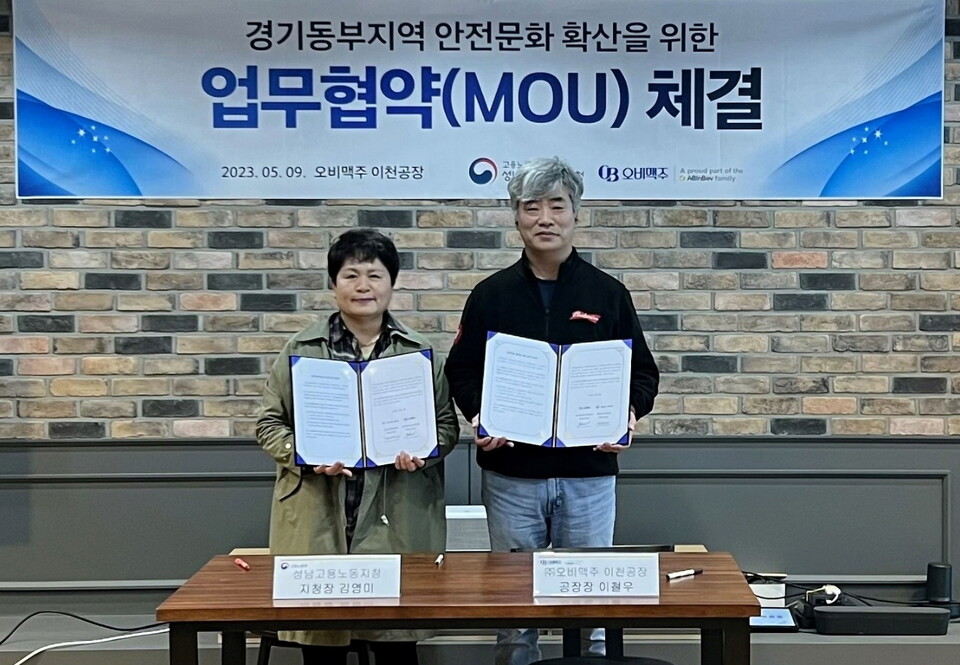 오비맥주 이천공장에서 열린 ‘경기동부지역의 안전문화 확산’을 위한 업무협약(MOU)식에서 김영미 고용노동부 성남지청장(왼쪽)이 이철우 오비맥주 이천공장장(오른쪽)과 함께 기념촬영을 하고 있다. (사진제공=오비맥주)(사진=제공)