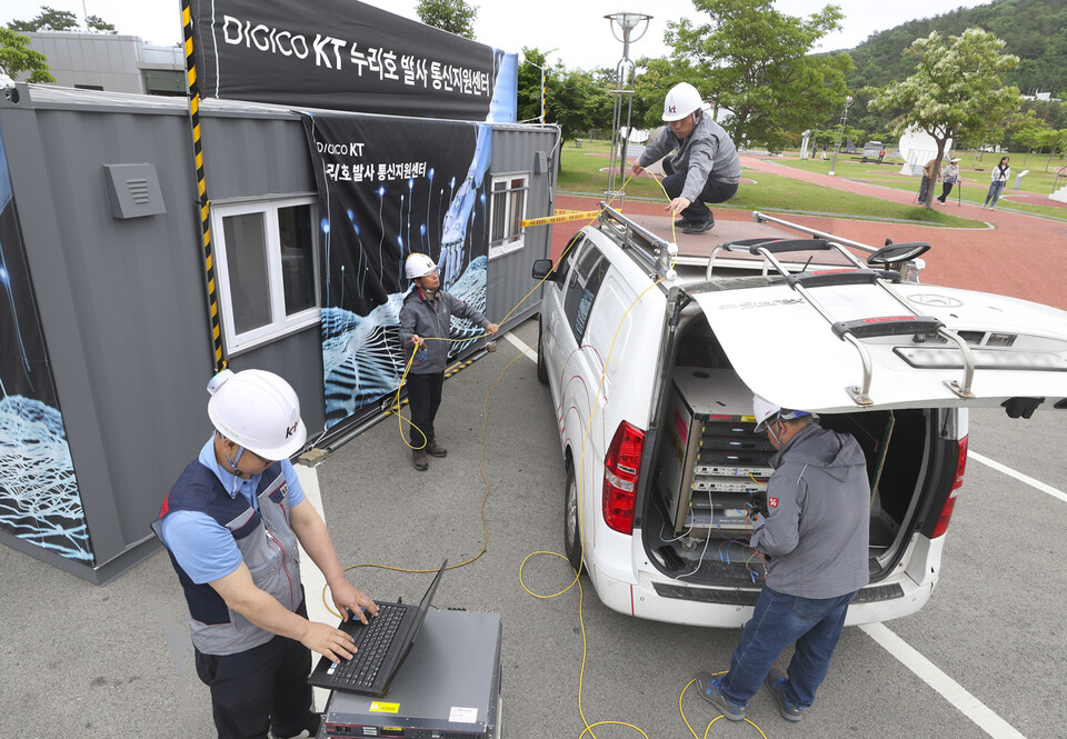KT 직원들이 누리호 발사 순간을 전 세계로 원활하게 중계하기 위한 누리호 발사 통신지원센터를 나로우주센터 광장에 구축하고 방송회선을 점검하고 있다. (사진=KT 제공)