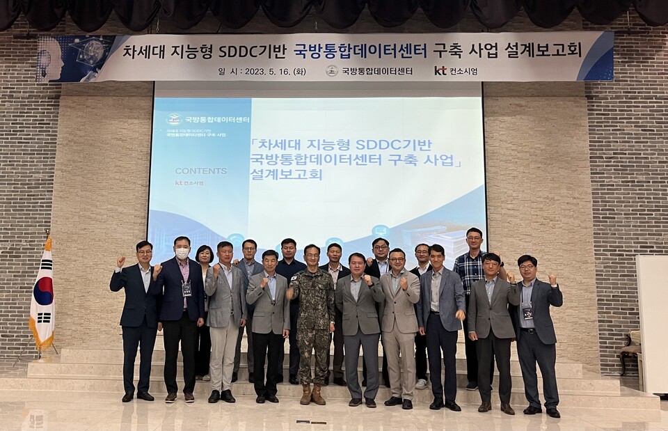 KT Cloud/DXO P-TF 정진수 상무(앞줄 왼쪽에서 일곱 번째)와 국방부 정보통신기반정책담당관 오세종 대령(왼쪽에서 네 번째), 국방통합데이터센터 1센터장 조재명 대형(왼쪽에서 다섯 번째), 국방통합데이터센터 2센터장 문창기 대령(왼쪽에서 세 번째) 등이 설계 보고회 후 기념 촬영을 하고 있다. (사진=KT 제공)